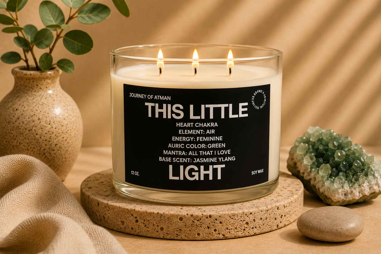 This Little Light heart chakra candle by Journey of Atman displayed in a warm spa-inspired setting with green crystal accents, soft neutral textures, and ambient candlelight.
