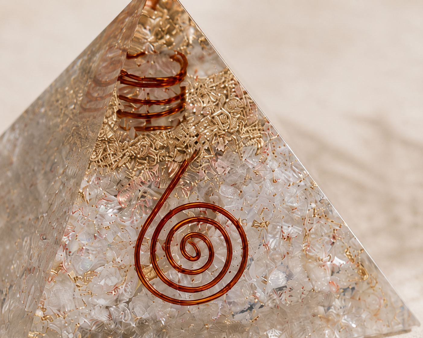 Close-up detail of clear quartz orgonite pyramid featuring crystal texture, copper coil, and resin craftsmanship.