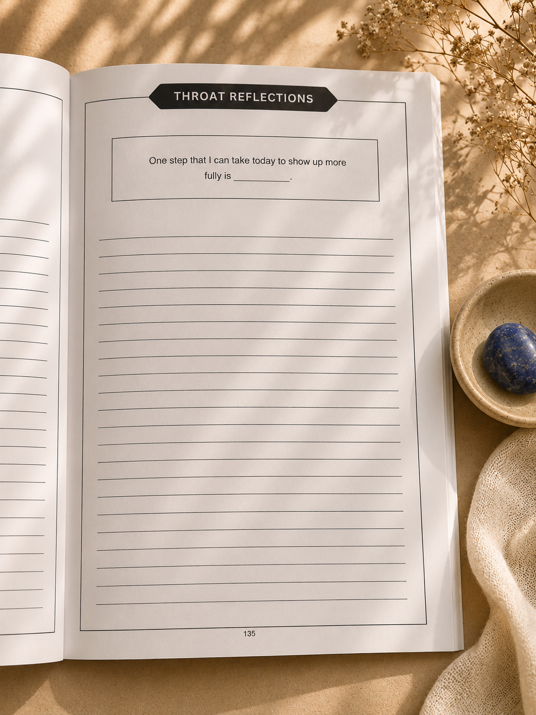 Throat Chakra guided reflection page photographed in serene cream-toned lifestyle scene with minimalist decor.