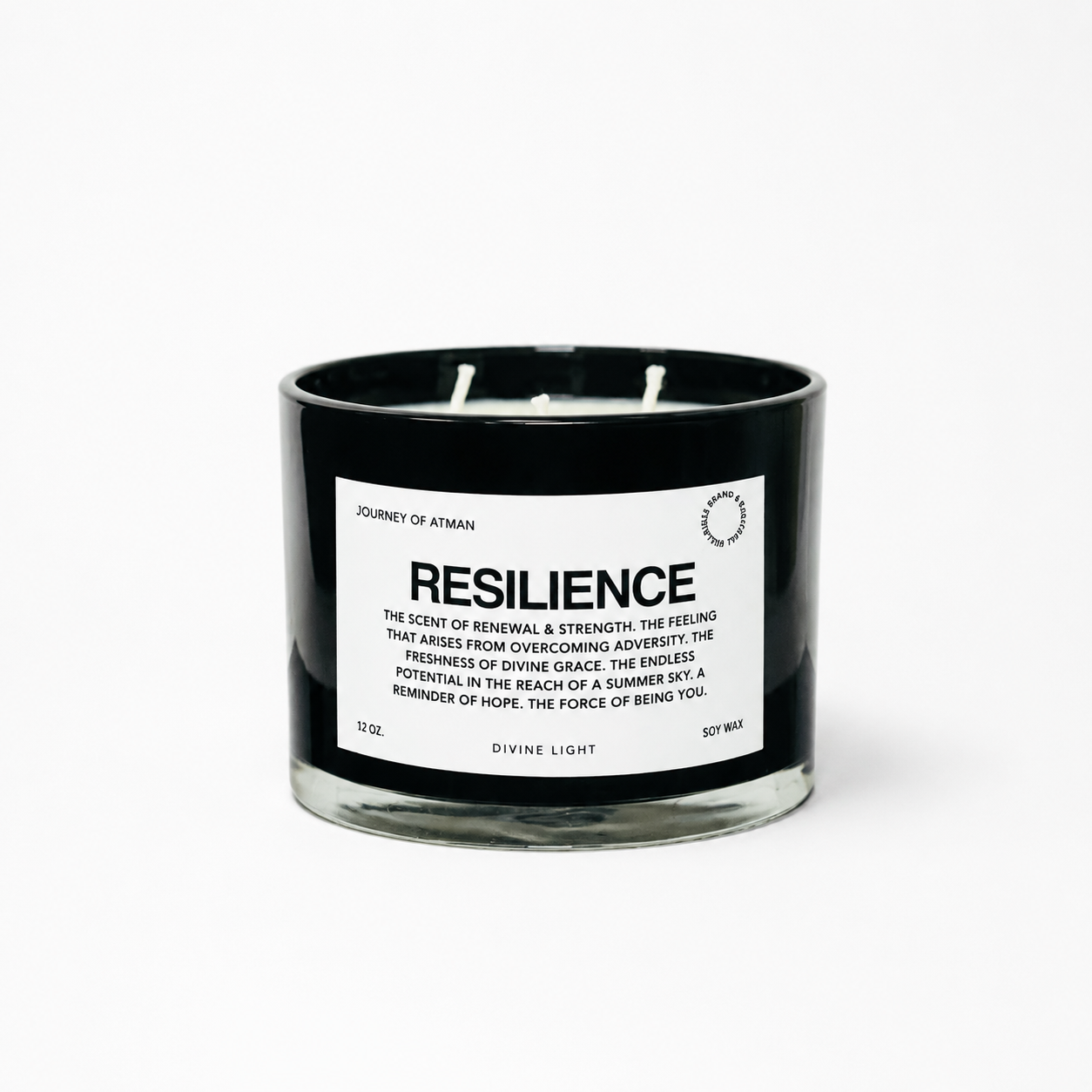 Resilience affirmation candle in black glass vessel with white label on clean white background supporting strength, renewal, and resilience.