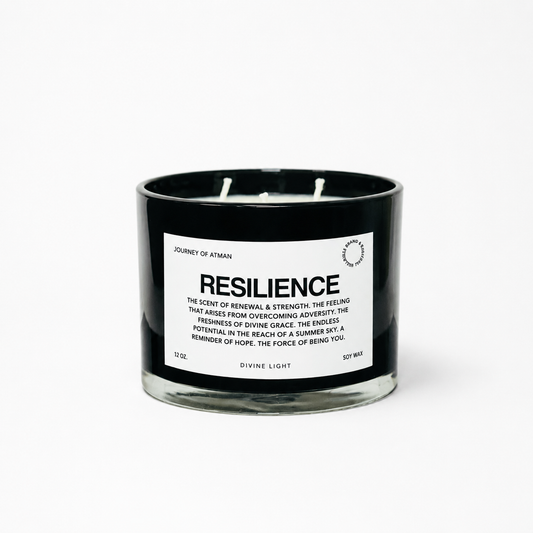 Resilience affirmation candle in black glass vessel with white label on clean white background supporting strength, renewal, and resilience.