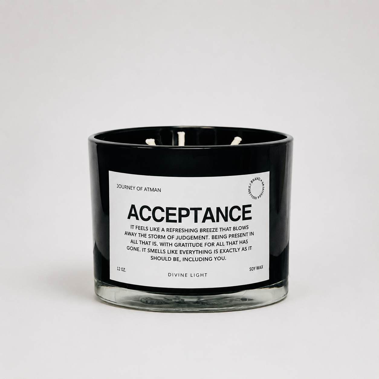 Acceptance affirmation candle in black glass vessel with white label on clean white background supporting peace, self-compassion, and grounding.