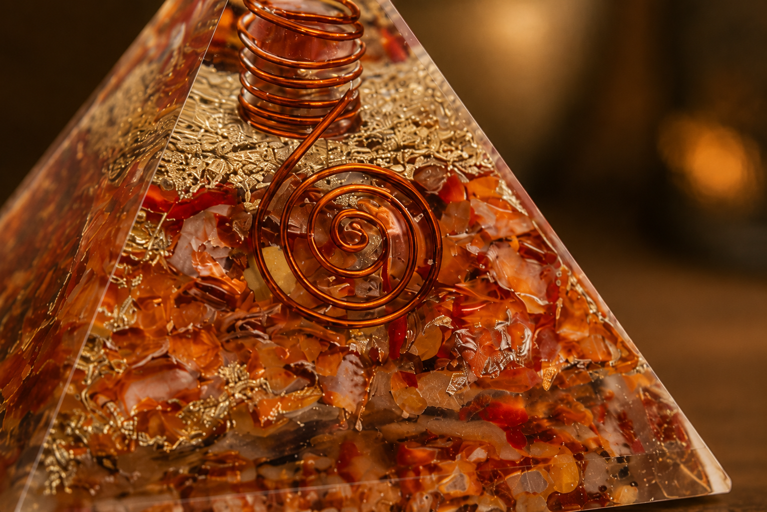 Close-up detail of carnelian orgonite pyramid featuring crystal texture, copper coil, and resin craftsmanship.