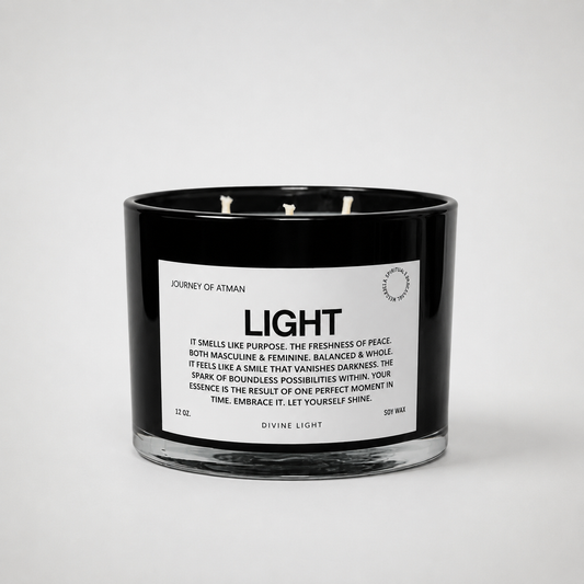 Light affirmation candle in black glass vessel with white label on clean white background symbolizing hope, clarity, and guidance.
